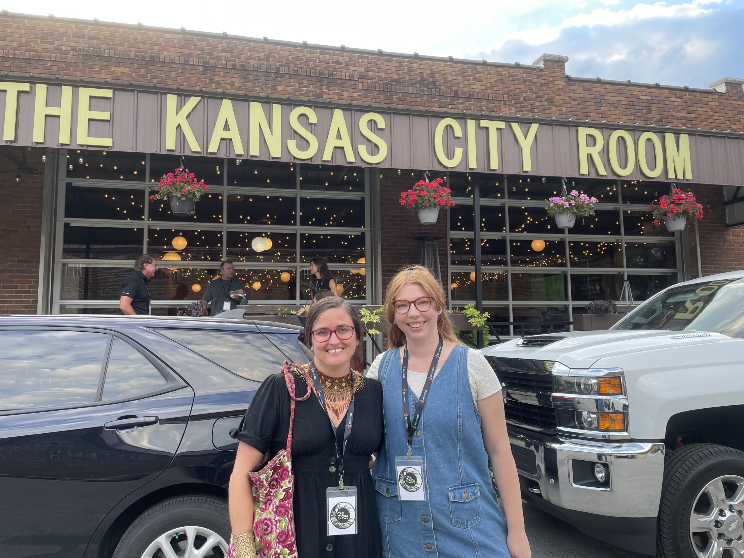 Marketing team poses in front of the Kansas City Room venue